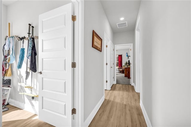 corridor featuring light wood-style flooring, baseboards, and visible vents