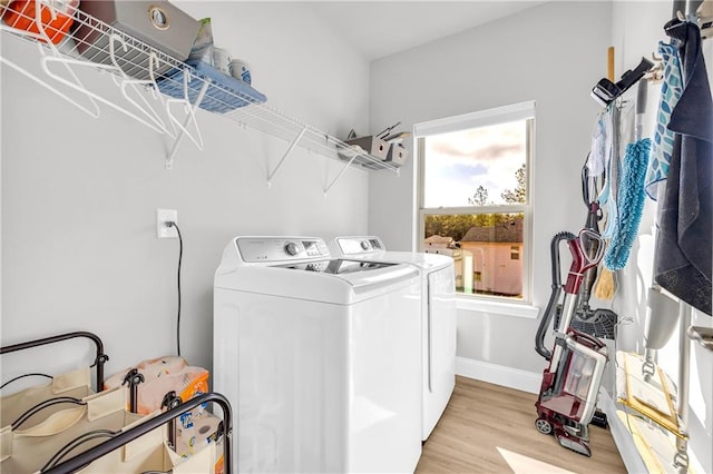 laundry area with laundry area, separate washer and dryer, light wood-style floors, and baseboards