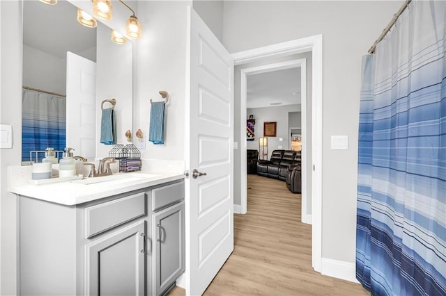 full bathroom with vanity, baseboards, and wood finished floors