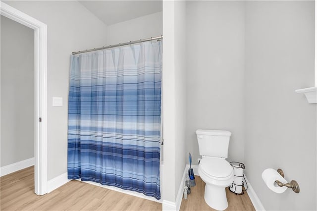 full bathroom with a shower with shower curtain, baseboards, and wood finished floors