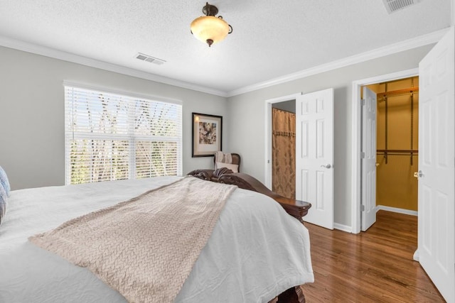 420 Heritage Park Trce NW Unit 22, Kennesaw, GA 30144 - bedroom featuring crown molding, wood finished floors, a spacious closet, a textured ceiling, and a closet