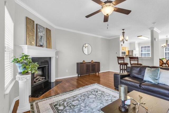 420 Heritage Park Trce NW Unit 22, Kennesaw, GA 30144 - living area featuring wood finished floors, a chandelier, ornamental molding, a ceiling fan, and a fireplace with flush hearth