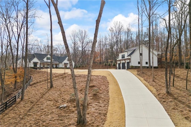 view of yard featuring fence and concrete driveway