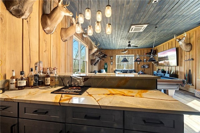 bathroom with wood ceiling, wood finished floors, visible vents, and wooden walls