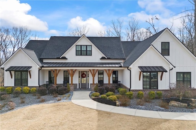 modern farmhouse style home with board and batten siding, a standing seam roof, brick siding, and a porch