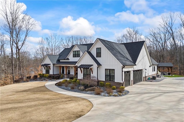 modern farmhouse featuring driveway, metal roof, a standing seam roof, board and batten siding, and brick siding