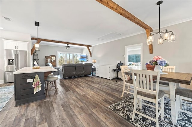 dining room with visible vents, dark wood finished floors, a ceiling fan, beamed ceiling, and crown molding