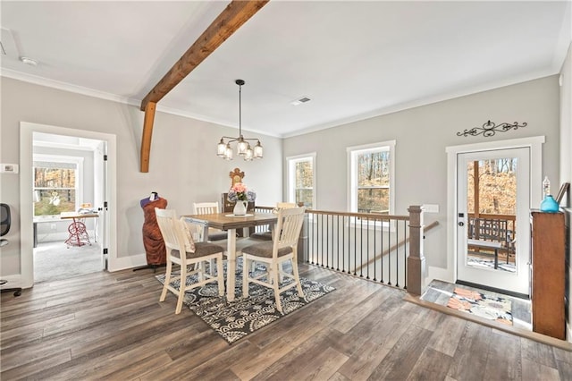 dining room with dark wood-type flooring, a notable chandelier, crown molding, and baseboards