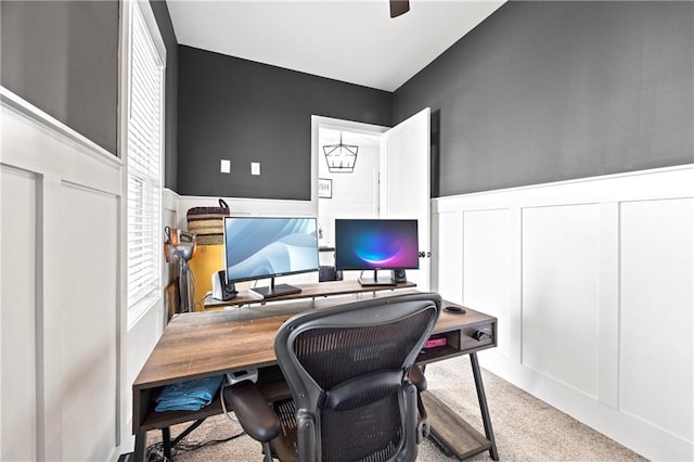 carpeted office featuring a decorative wall and wainscoting