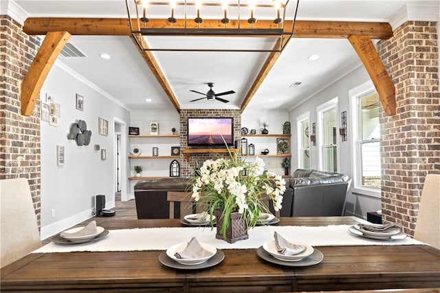 dining room with baseboards, brick wall, wood finished floors, crown molding, and a fireplace