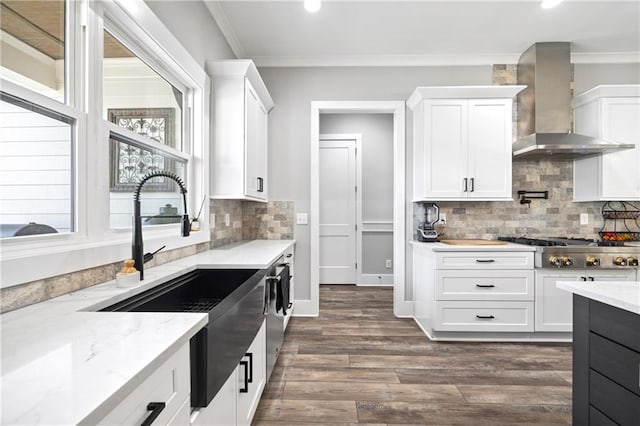 kitchen with wall chimney exhaust hood, appliances with stainless steel finishes, and white cabinetry