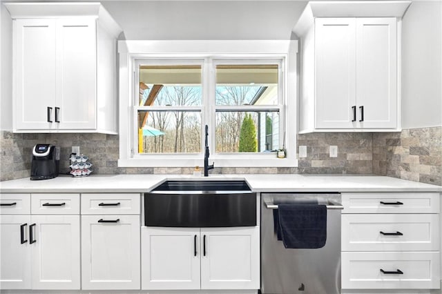 kitchen featuring dishwasher, light countertops, and white cabinets