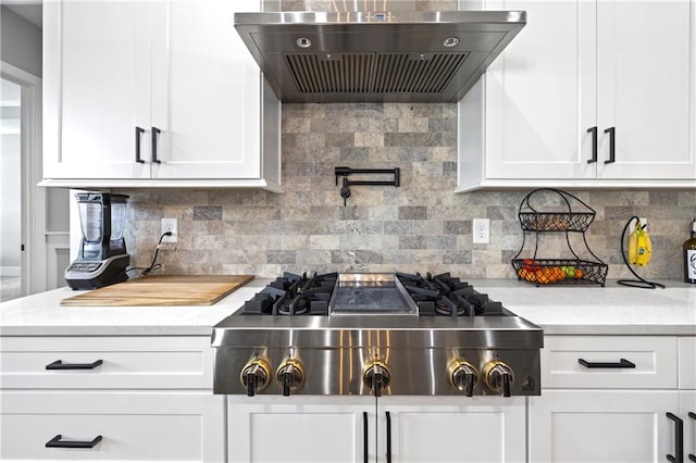 kitchen featuring wall chimney range hood, white cabinetry, and stainless steel gas stovetop