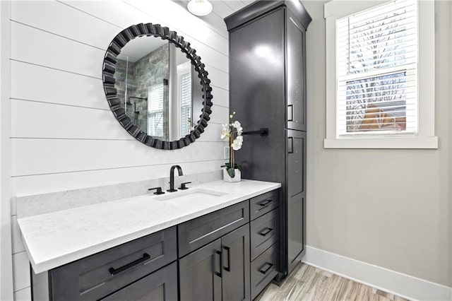 bathroom with wood finished floors, vanity, and baseboards