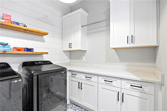 clothes washing area featuring cabinet space and separate washer and dryer