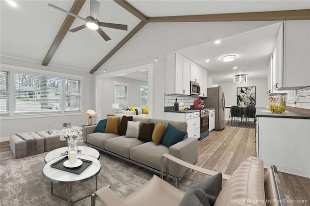 1573 Deerwood Ln, Acworth, GA 30102 - living room with a healthy amount of sunlight, ceiling fan, lofted ceiling with beams, and light wood-type flooring