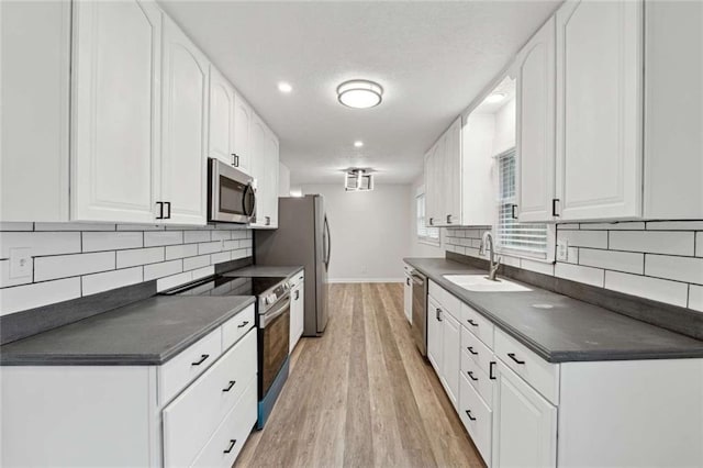 1573 Deerwood Ln, Acworth, GA 30102 - kitchen featuring backsplash, stainless steel appliances, sink, light hardwood / wood-style floors, and white cabinetry