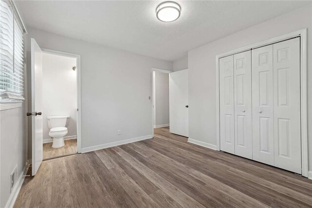 1573 Deerwood Ln, Acworth, GA 30102 - unfurnished bedroom featuring ensuite bathroom, a closet, and hardwood / wood-style flooring
