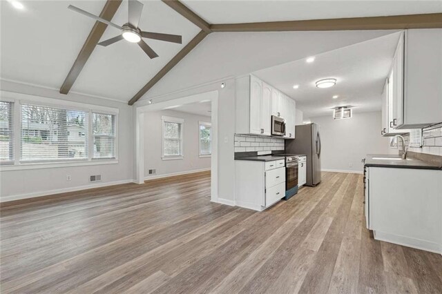 1573 Deerwood Ln, Acworth, GA 30102 - kitchen with appliances with stainless steel finishes, light wood-type flooring, sink, lofted ceiling with beams, and white cabinetry