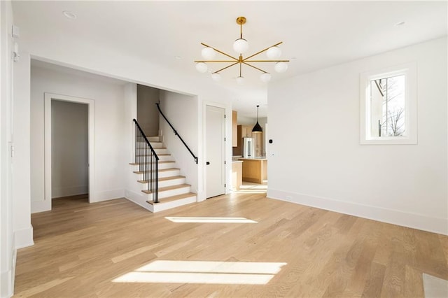 interior space with a notable chandelier and light wood-type flooring