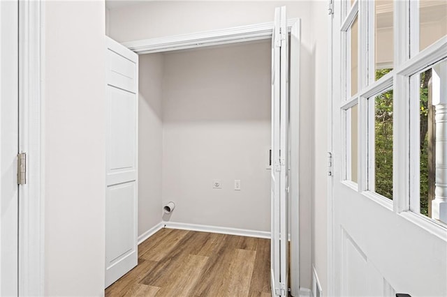 laundry room with light wood-style floors, baseboards, laundry area, and hookup for an electric dryer