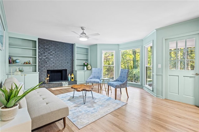 sunroom / solarium featuring plenty of natural light, a ceiling fan, and a brick fireplace