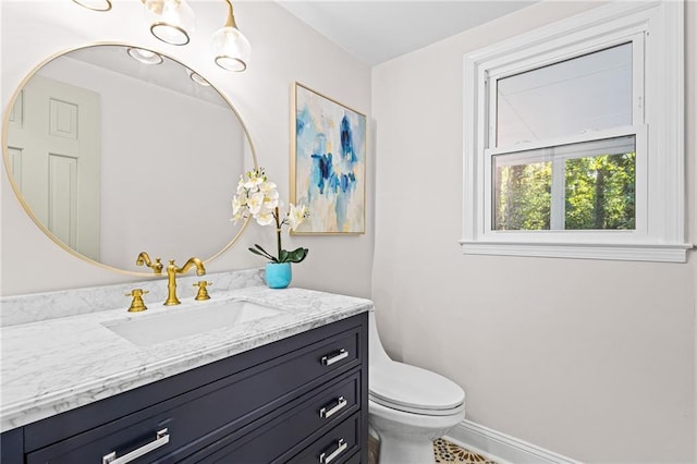 bathroom with vanity, toilet, and baseboards