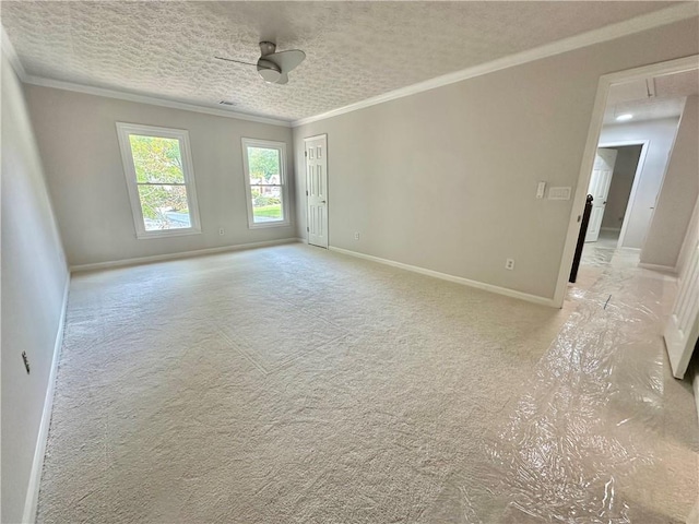 spare room with crown molding, attic access, ceiling fan, a textured ceiling, and baseboards