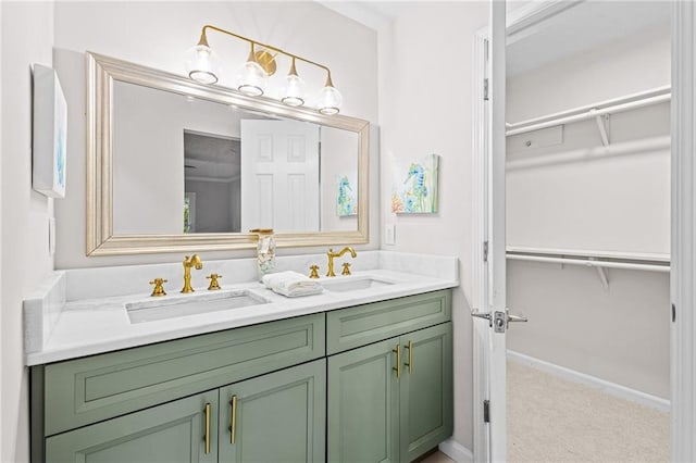 bathroom with double vanity, a sink, and a walk in closet