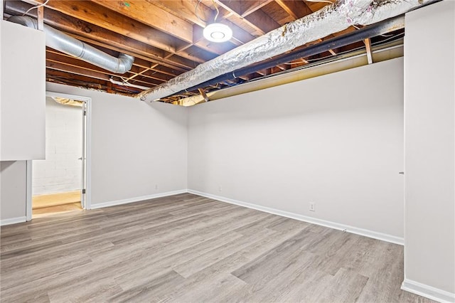 unfinished below grade area with baseboards and wood finished floors