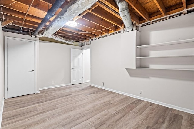 unfinished below grade area with wood finished floors and baseboards