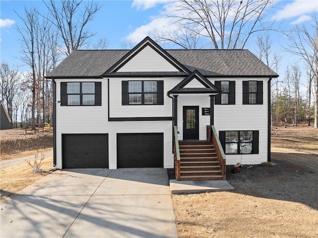 split foyer home featuring a garage, concrete driveway, and roof with shingles