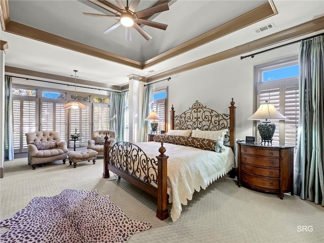 bedroom featuring crown molding, a tray ceiling, and light colored carpet