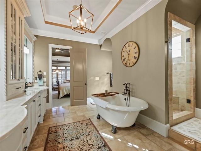 ensuite bathroom featuring a raised ceiling, a freestanding bath, a shower stall, and ensuite bathroom