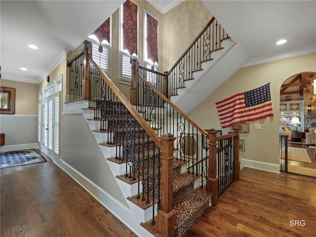 stairway with baseboards, ornamental molding, wood finished floors, and recessed lighting