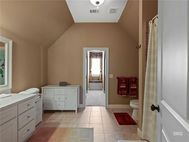 full bath featuring tile patterned flooring, toilet, vanity, visible vents, and vaulted ceiling