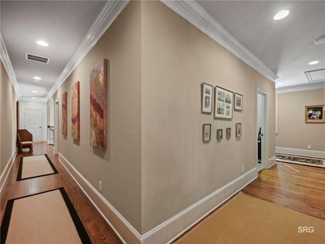 hallway with recessed lighting, visible vents, wood finished floors, and ornamental molding