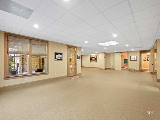 interior space featuring baseboards, a drop ceiling, and recessed lighting