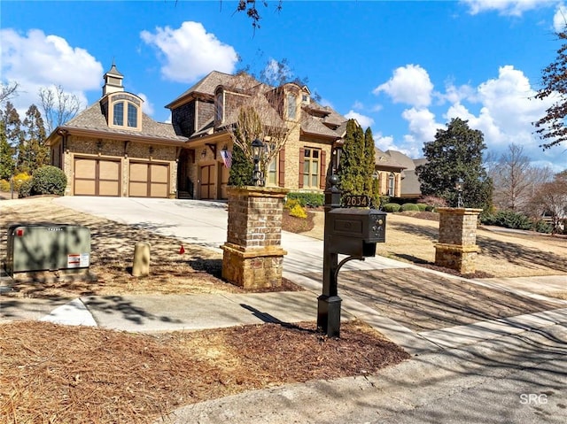 view of front of property featuring a garage, driveway, and brick siding