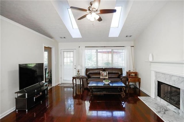 living area with baseboards, a ceiling fan, wood finished floors, and a high end fireplace