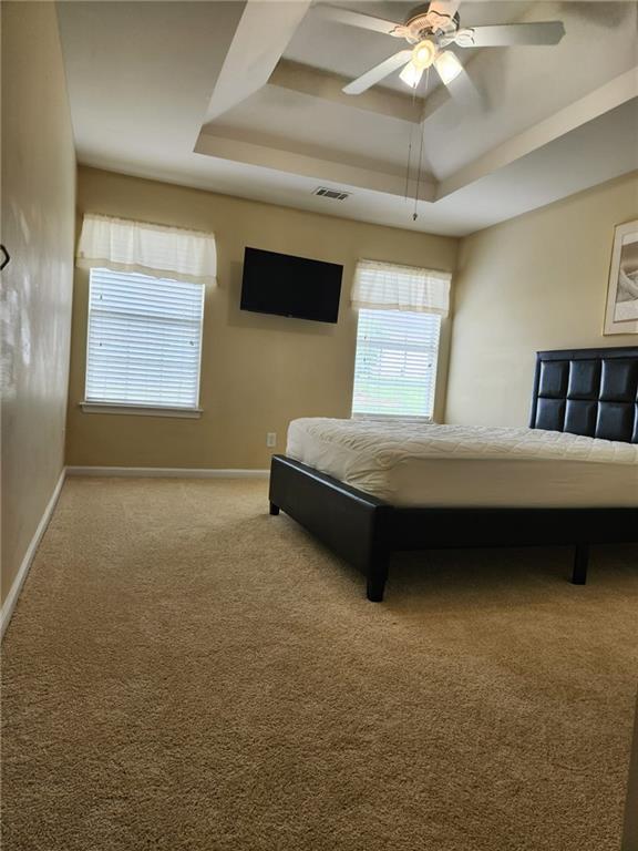 1441 Saint George Pl, Conyers, GA 30012 - carpeted bedroom featuring a raised ceiling and a ceiling fan