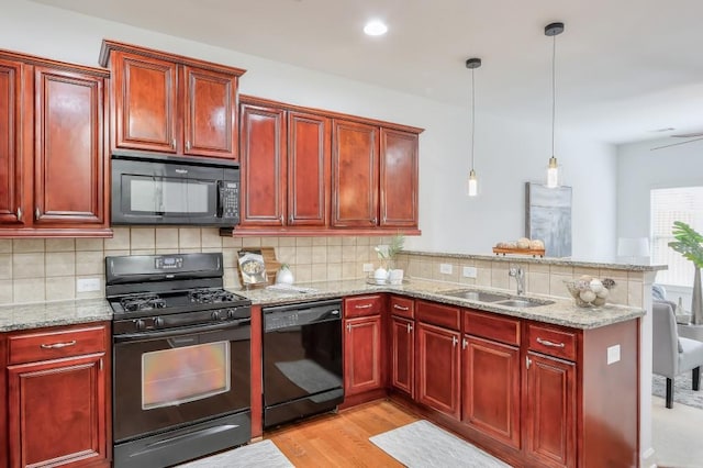 kitchen featuring a sink, black appliances, and dark brown cabinets