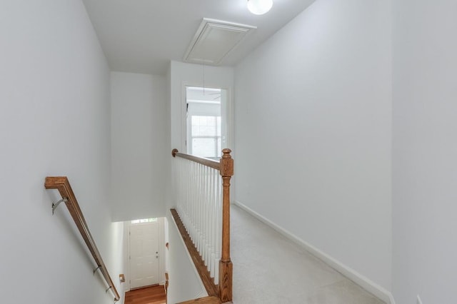 staircase featuring attic access and baseboards