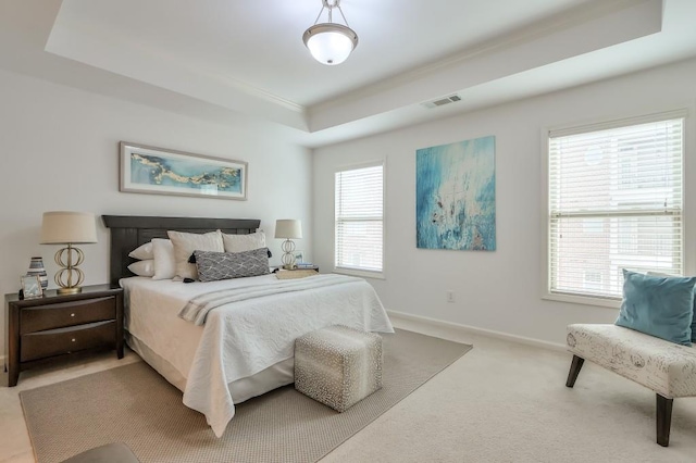 bedroom with baseboards, visible vents, a raised ceiling, and light colored carpet