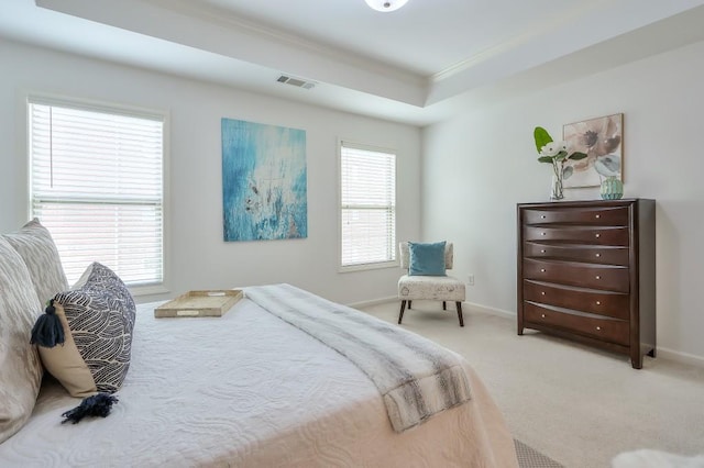 bedroom featuring multiple windows, baseboards, a tray ceiling, and light colored carpet