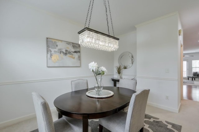 dining area with baseboards, carpet, and crown molding