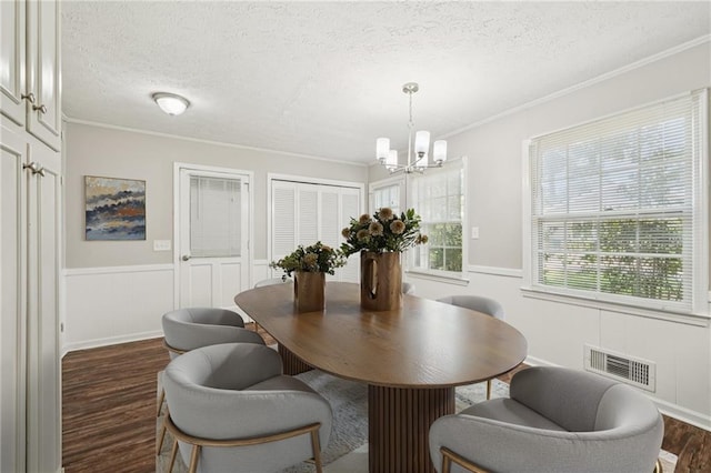 2466 Country Club Dr, Conyers, GA 30013 - dining room featuring dark wood finished floors, a textured ceiling, a chandelier, wainscoting, and crown molding