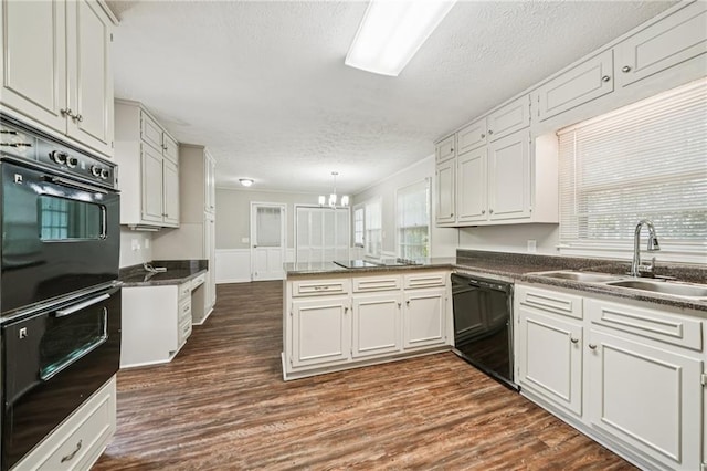2466 Country Club Dr, Conyers, GA 30013 - kitchen featuring black appliances, a peninsula, a textured ceiling, dark countertops, and dark wood-style floors