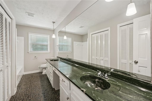 2466 Country Club Dr, Conyers, GA 30013 - bathroom with a closet, double vanity, shower / bathtub combination, and a textured ceiling