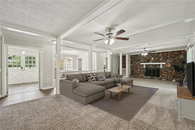 2466 Country Club Dr, Conyers, GA 30013 - living area featuring a ceiling fan, a stone fireplace, a textured ceiling, beam ceiling, and a chandelier